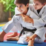 Two kids practicing Brazilian Jiu-Jitsu on mats